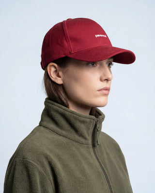 Profil d’une femme portant la casquette Pavenrod bordeaux en coton bio, casquette de randonnée pour sorties en plein air.
