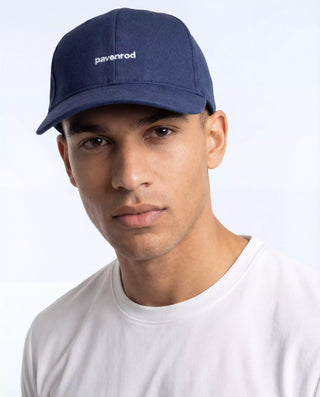 Portrait d’un homme portant la casquette Pavenrod bleu marine en coton bio, accessoire outdoor pour randonnée et voyage.