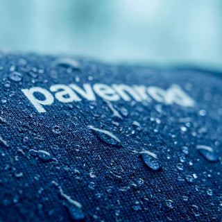 Gros plan sur tissu Pavenrod avec gouttes d’eau et logo, détail du haut technique outdoor Made in France.