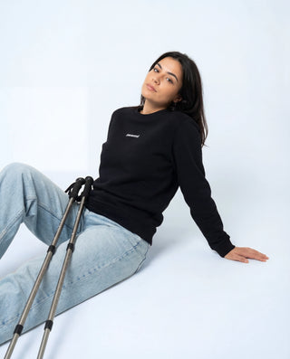 Femme en sweat Pavenrod noir coton bio et polyester, fabriqué en France, photo lifestyle en studio.