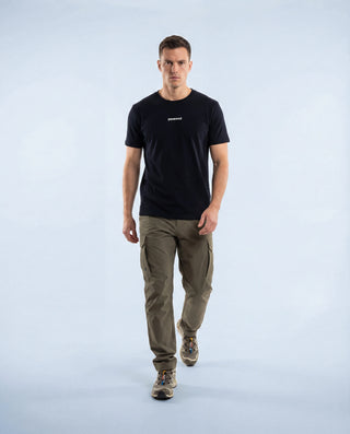 T-shirt outdoor Pavenrod noir en coton bio, fabrication France, porté par un homme, vue face en marche, photo studio fond clair.